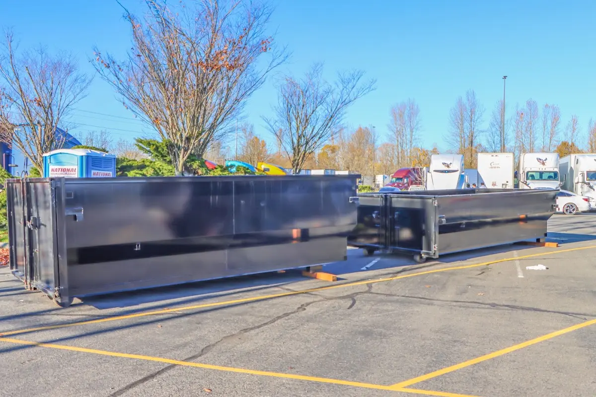 Professional dumpster rental service with roll-off container on residential driveway in Wilton Manors